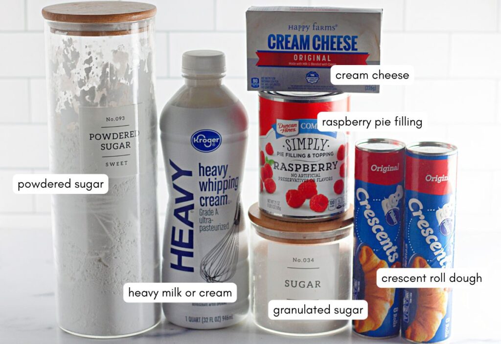 Top view of all the ingredients needed to make Raspberry Crescent Ring, including crescent roll dough, cream cheese, heavy cream, powdered and granulated sugar, and raspberry pie filling.