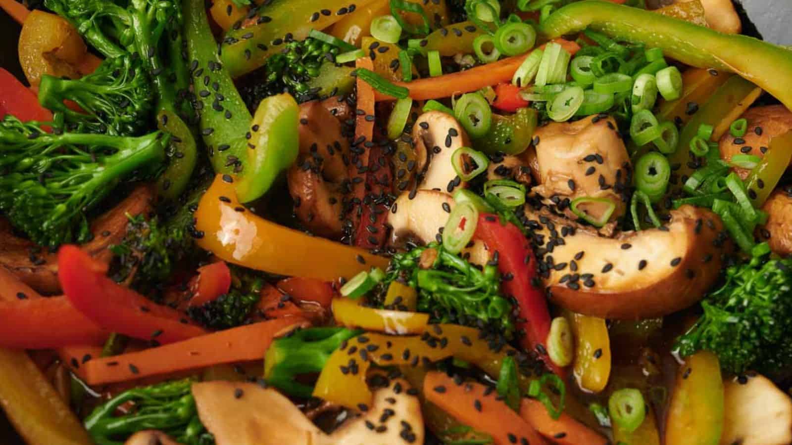 Colorful vegetable stir-fry with mushrooms, peppers, and black seeds.