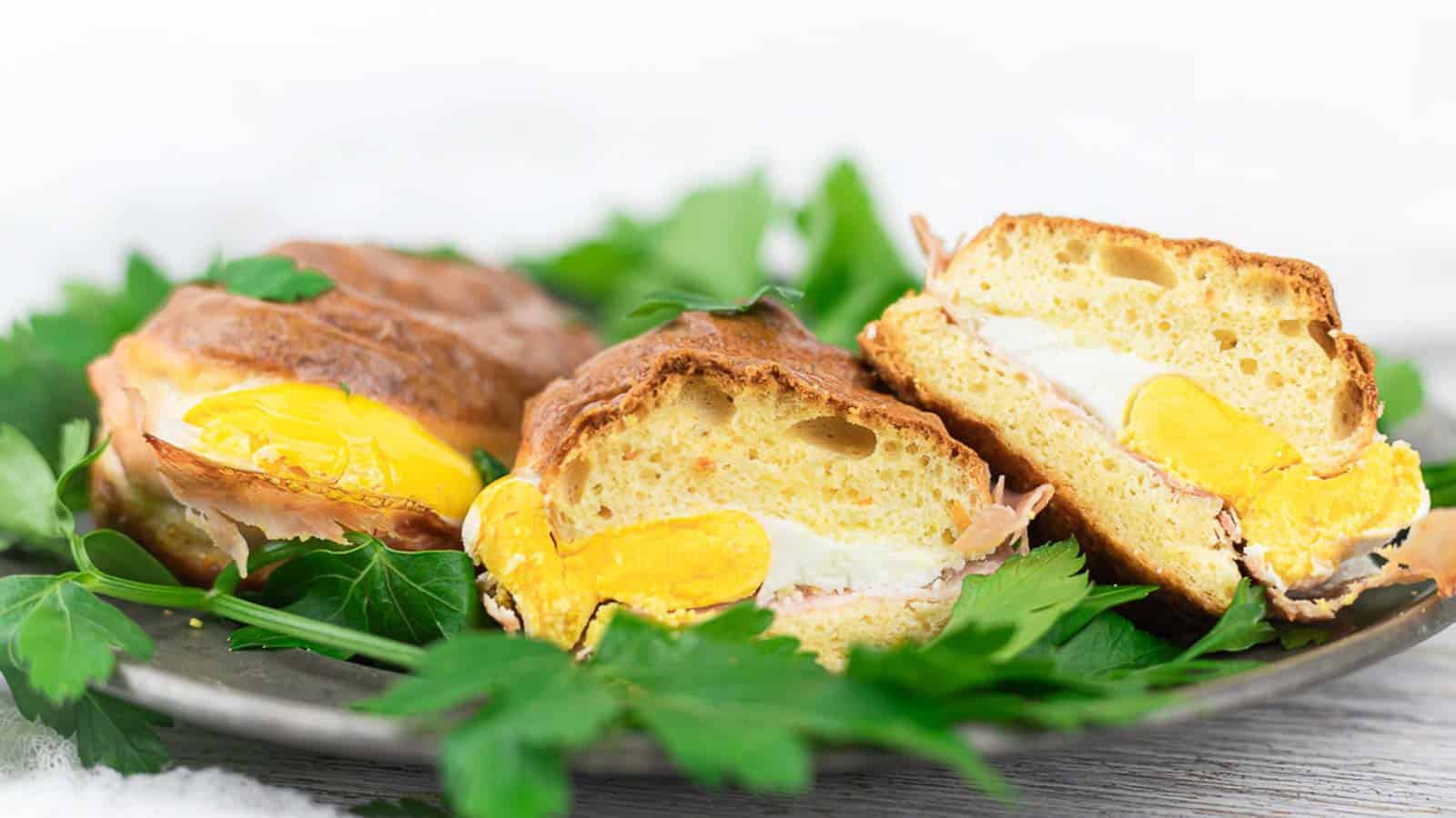 Breakfast Sandwich cut in half with herbs.