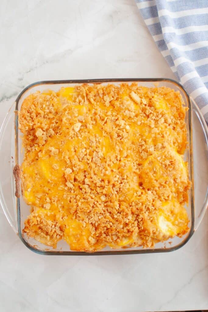 A freshly baked Southern Squash Casserole in a glass baking dish, topped with a golden, crispy cracker and cheese crust.