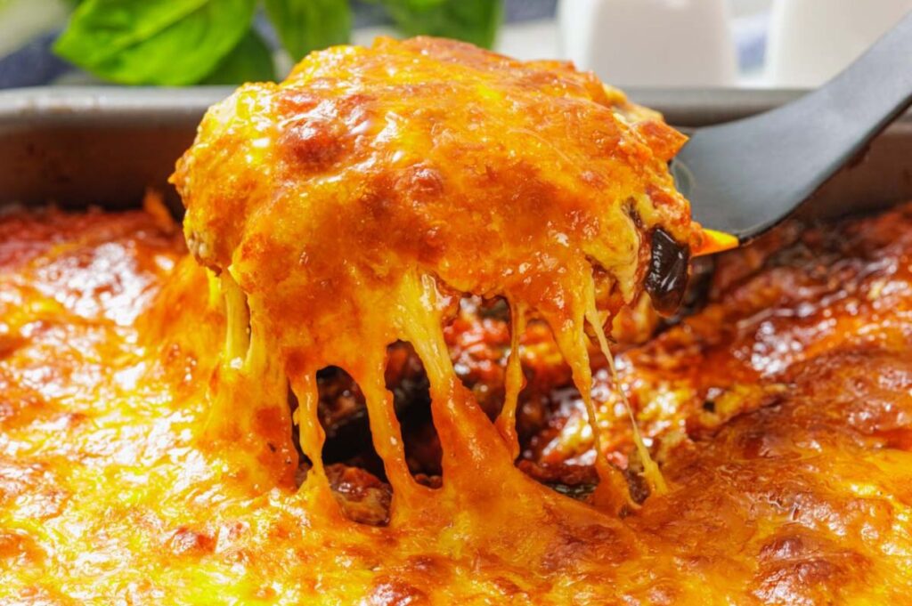 Cheesy eggplant parmigiana in a baking dish.