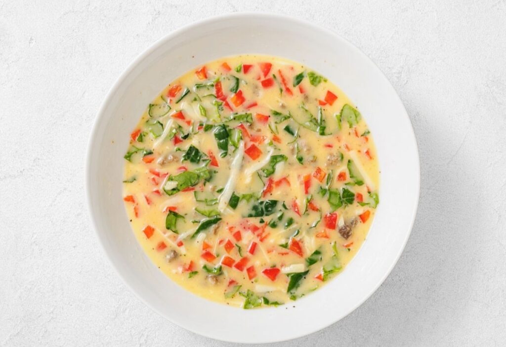 Creamy soup with peppers, greens, cheese, and sausage.