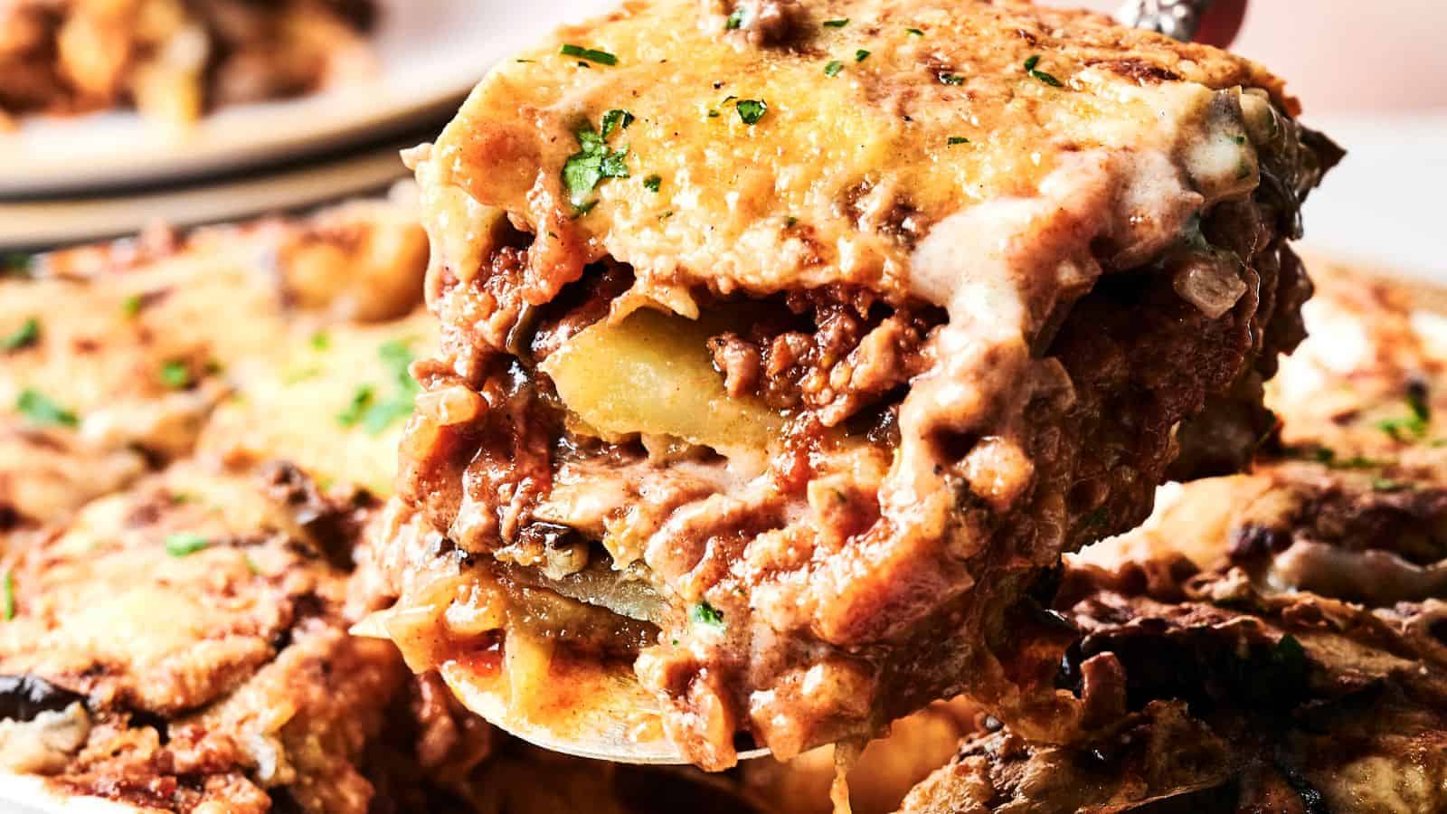 A close-up of a serving of cheesy baked lasagna with visible layers of pasta, meat sauce, and melted cheese.