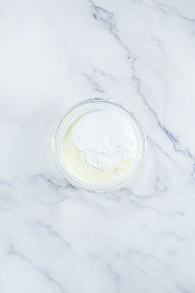 A bowl containing milk with powdered ingredients, ready for mixing.