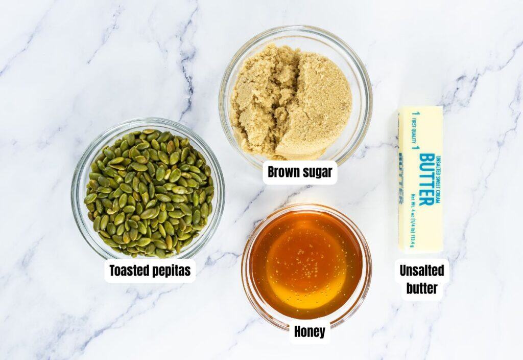 The image shows the ingredients for making pumpkin seed brittle: toasted pepitas, brown sugar, honey, and unsalted butter.