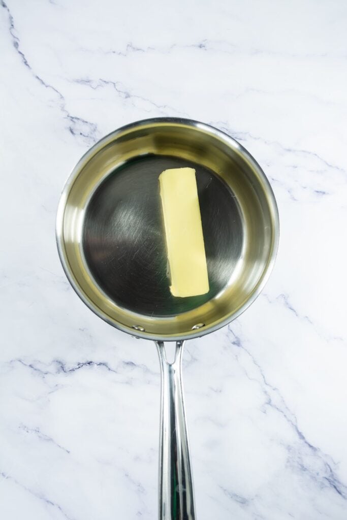 A stick of butter melting in a saucepan, ready to be used for the brittle.
