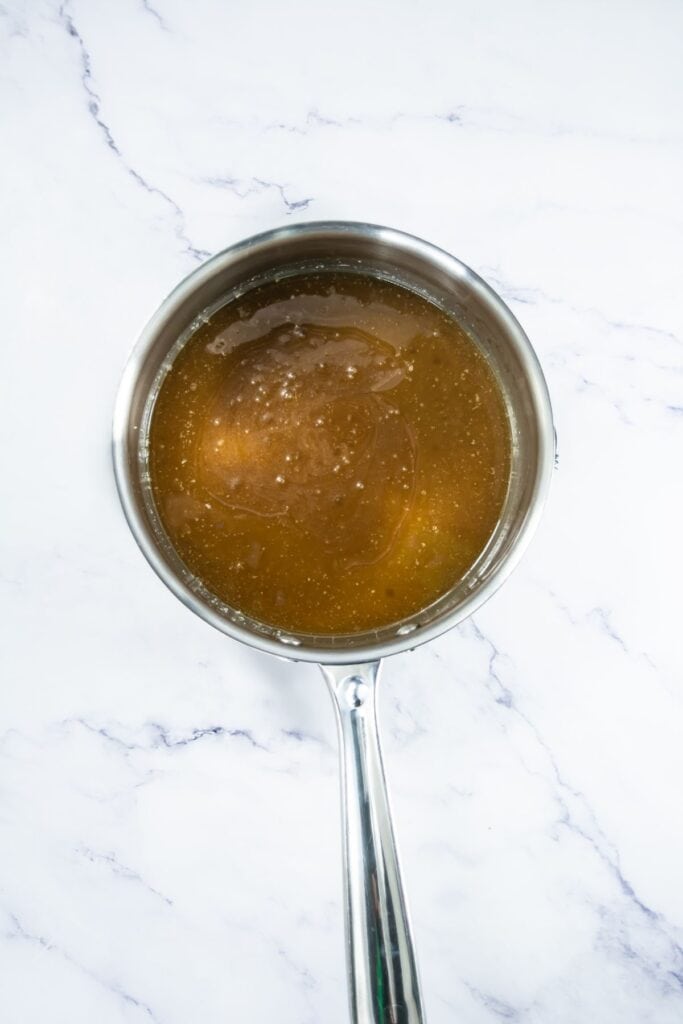 Caramel mixture in a saucepan after the butter, honey and sugar have been combined and melted.