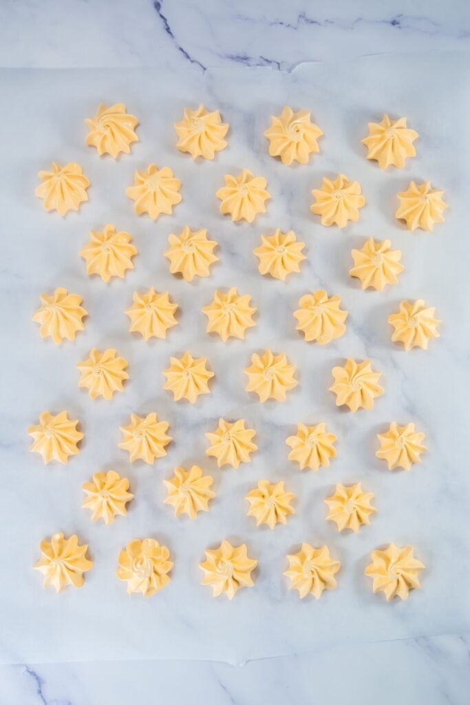 Ready-to-bake pumpkin meringues in a baking sheet