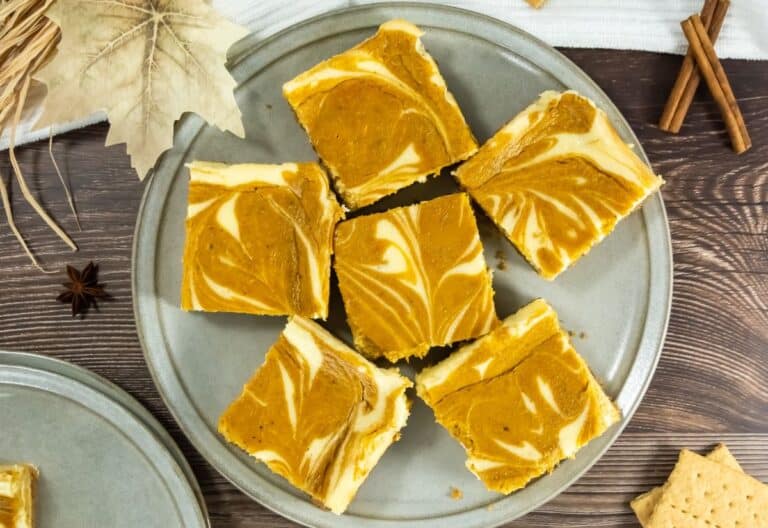 Pumpkin Cheesecake Bars on a gray plate, perfect for Southern Supper Club desserts.