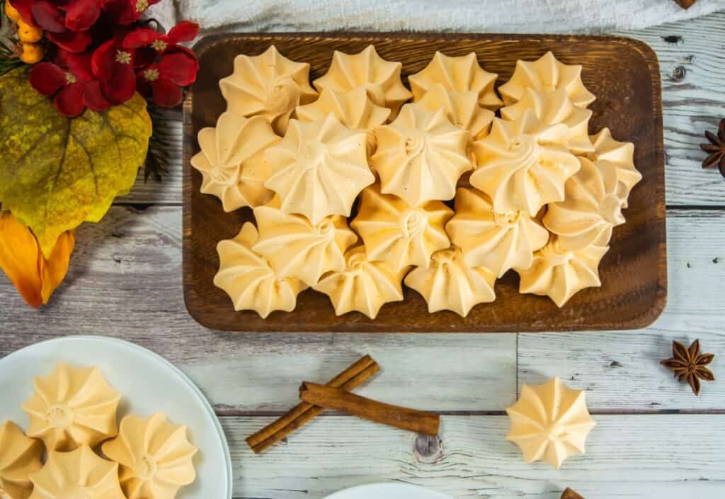 Pumpkin meringue cookies on wooden platter, autumn decor, Southern Supper Club, festive holiday dessert.