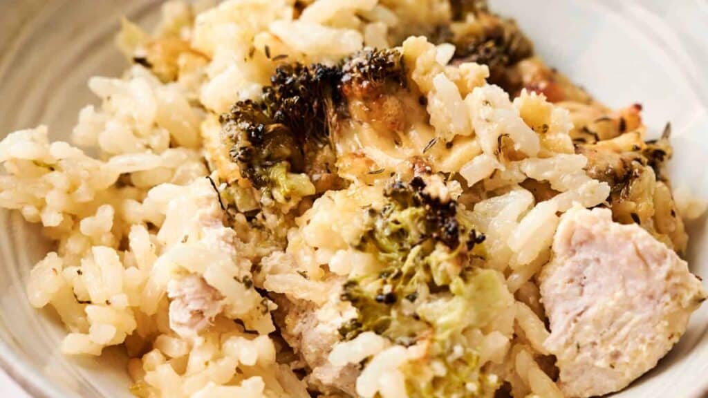 A serving of chicken and broccoli casserole with rice, featuring melted cheese and browned edges.