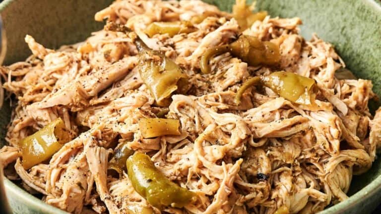 A tender pork roast cooked in a slow cooker, surrounded by flavorful gravy and served in a rustic dish.