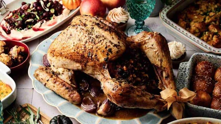 Roasted turkey with a crispy skin, served with cranberry stuffing on the side.