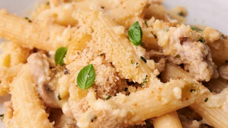 Pasta dish with creamy sauce, topped with fresh basil and grated cheese.