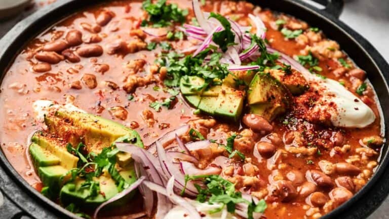 Hearty turkey chili with beans, topped with sliced avocado, red onion, and cilantro.