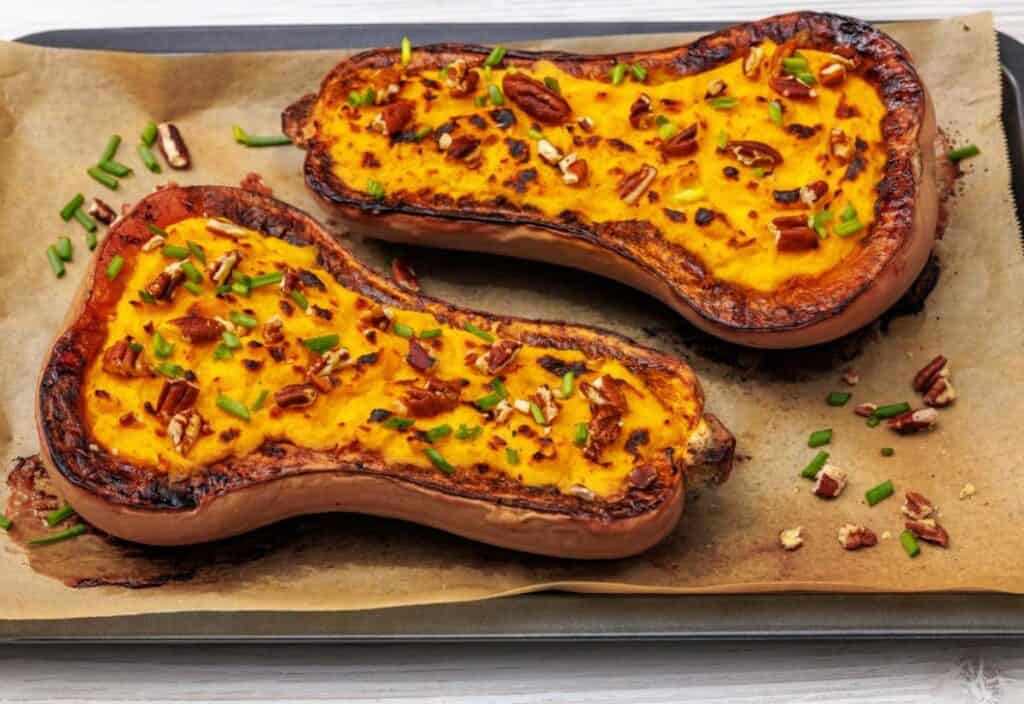 Two butternut squash halves filled with mashed squash and Parmesan, broiled until golden and topped with pecans and scallions.