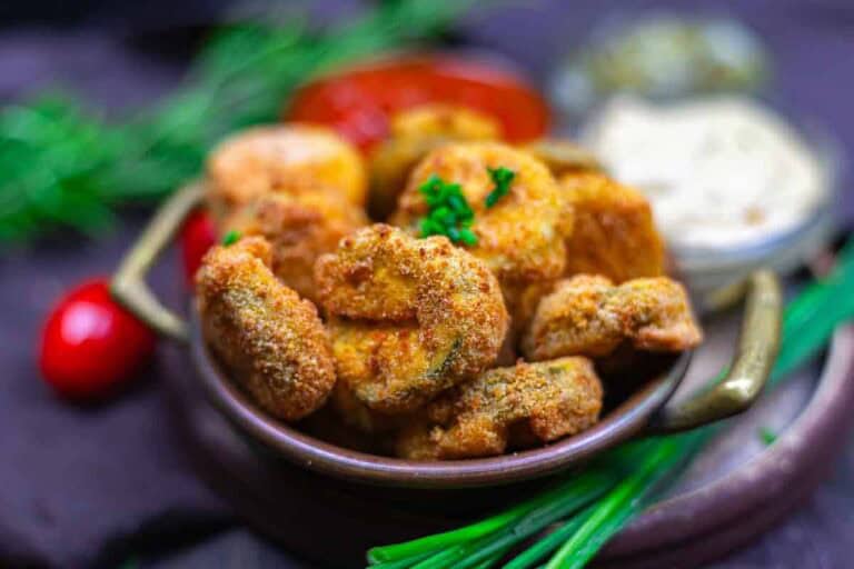 Crispy breaded mushrooms garnished with parsley, served with red and white dipping sauces and fresh herbs.
