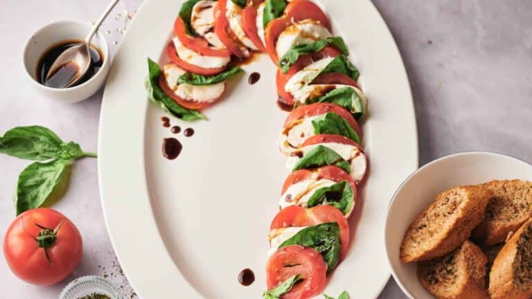 A creative twist on a Caprese salad, arranged in the shape of a candy cane with tomatoes, mozzarella, and basil.