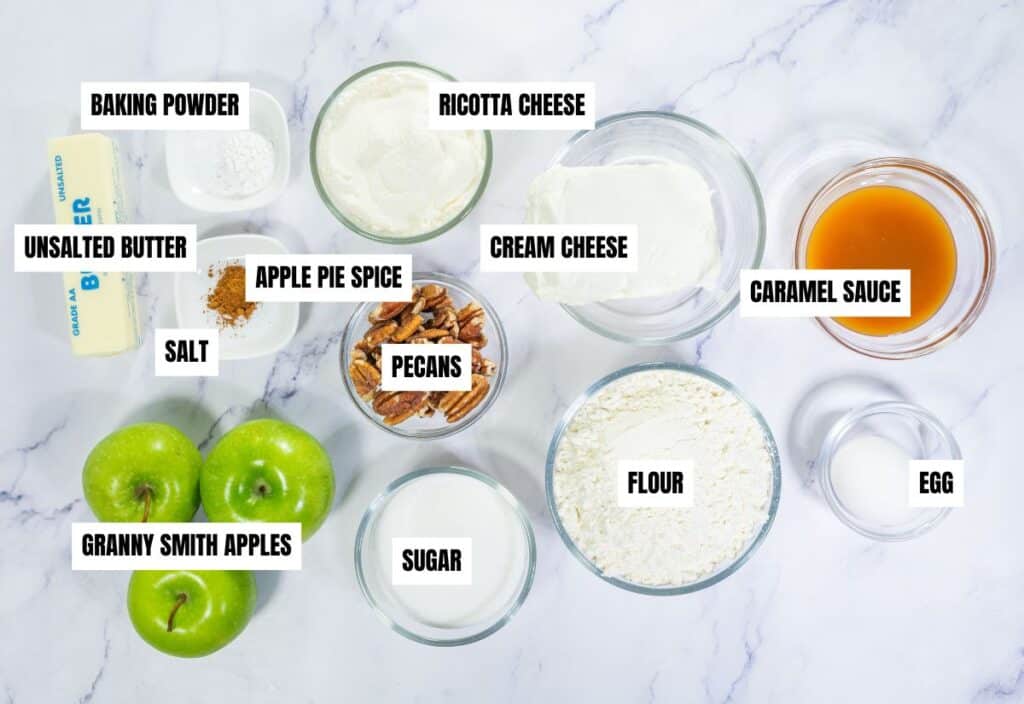 Ingredients for caramel apple pizza: Granny Smith apples, ricotta cheese, cream cheese, pecans, flour, sugar, egg, caramel sauce, apple pie spice, baking powder, unsalted butter, and salt.