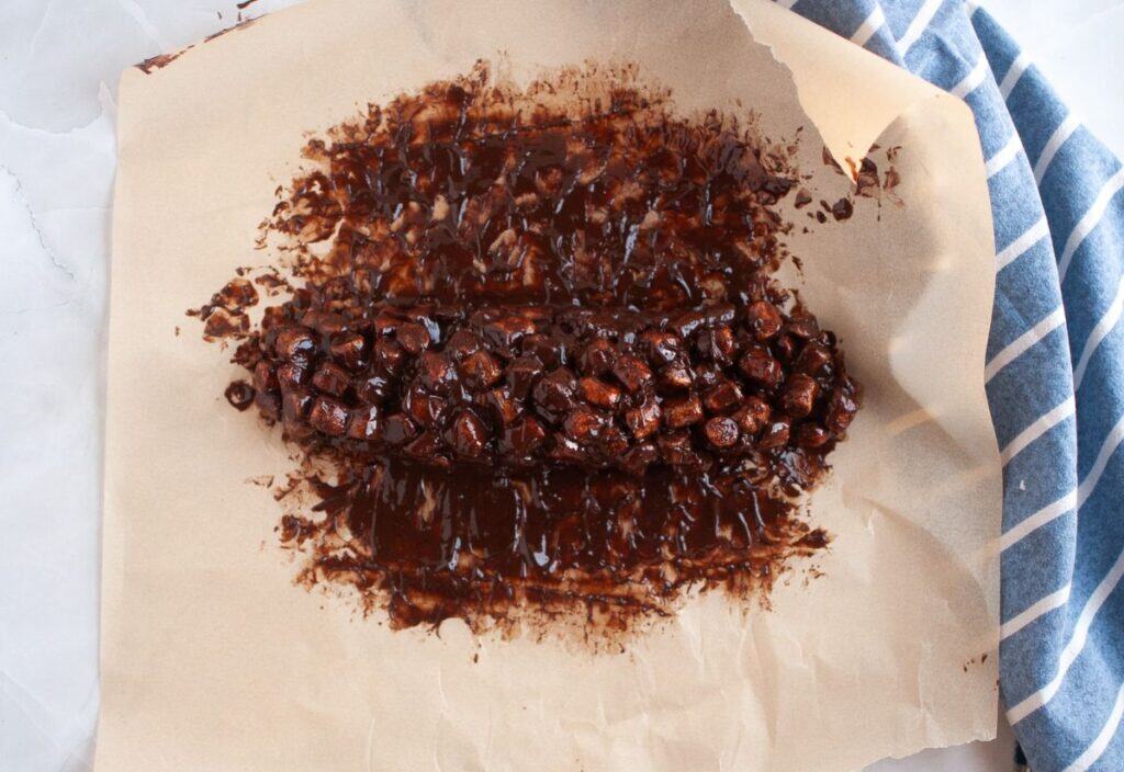 The chocolate and marshmallow mixture shaped into a rough log on waxed paper.