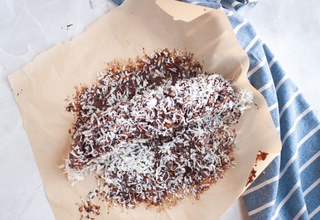 The chocolate log rolled in shredded coconut on waxed paper.