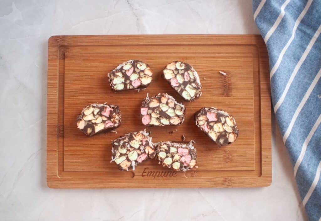 liced church window cookies arranged on a wooden cutting board, showing the colorful marshmallow centers.