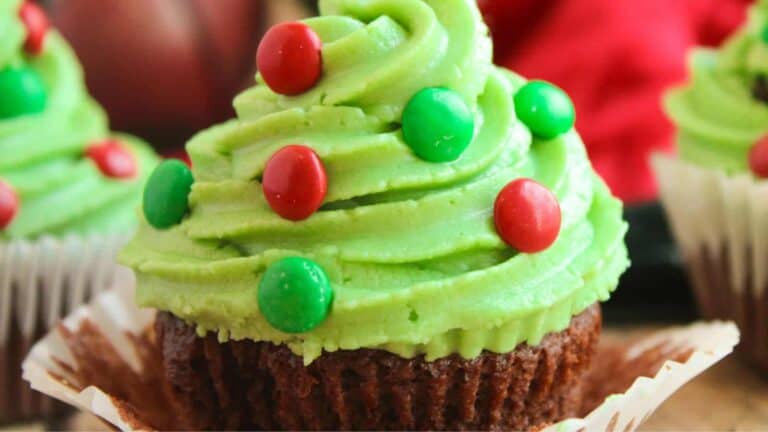 Cute Christmas tree cupcakes decorated with green frosting and colorful candy ornaments.