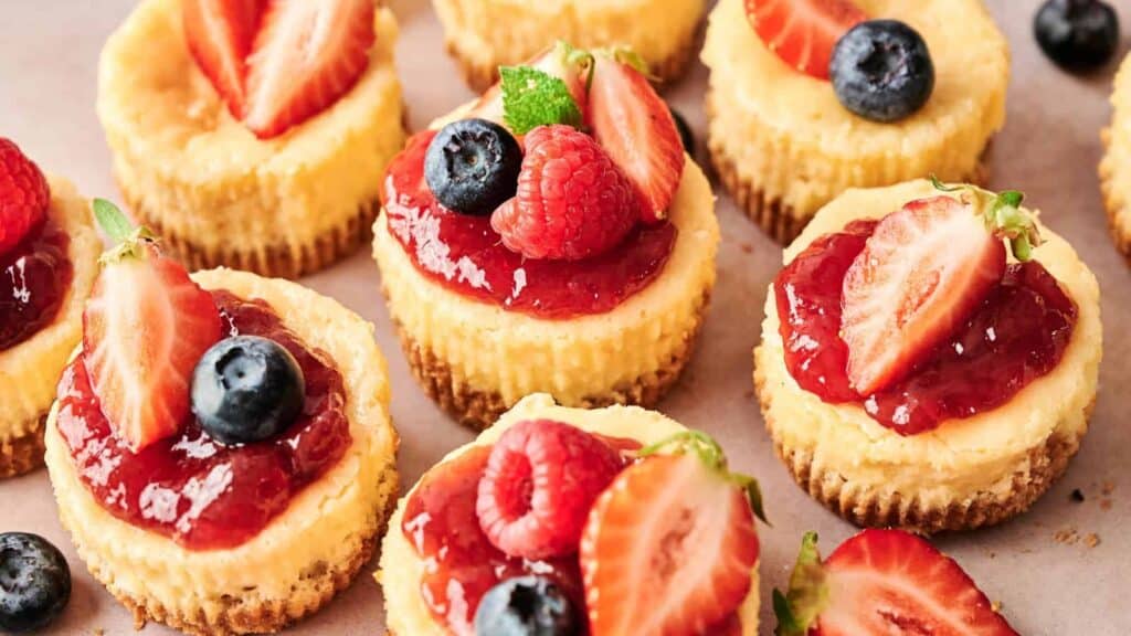 Individual mini cheesecakes topped with a variety of fresh berries and fruit compote.