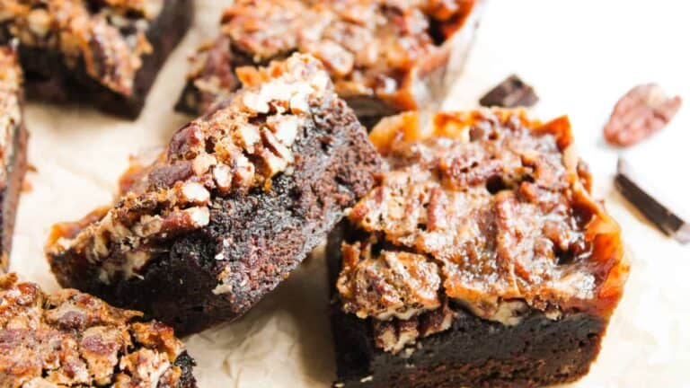 A close-up of pecan-topped brownies with a rich, gooey center and crispy edges.