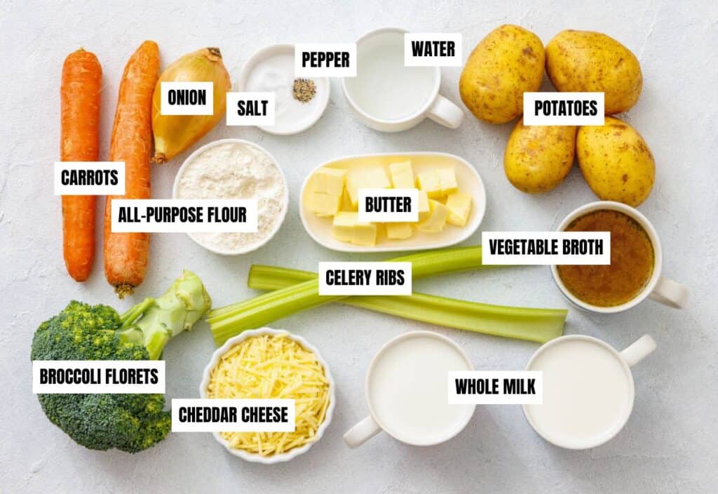 A flat lay of fresh ingredients for vegetable chowder, including carrots, celery, potatoes, broccoli, and other essentials like butter, flour, and vegetable broth.