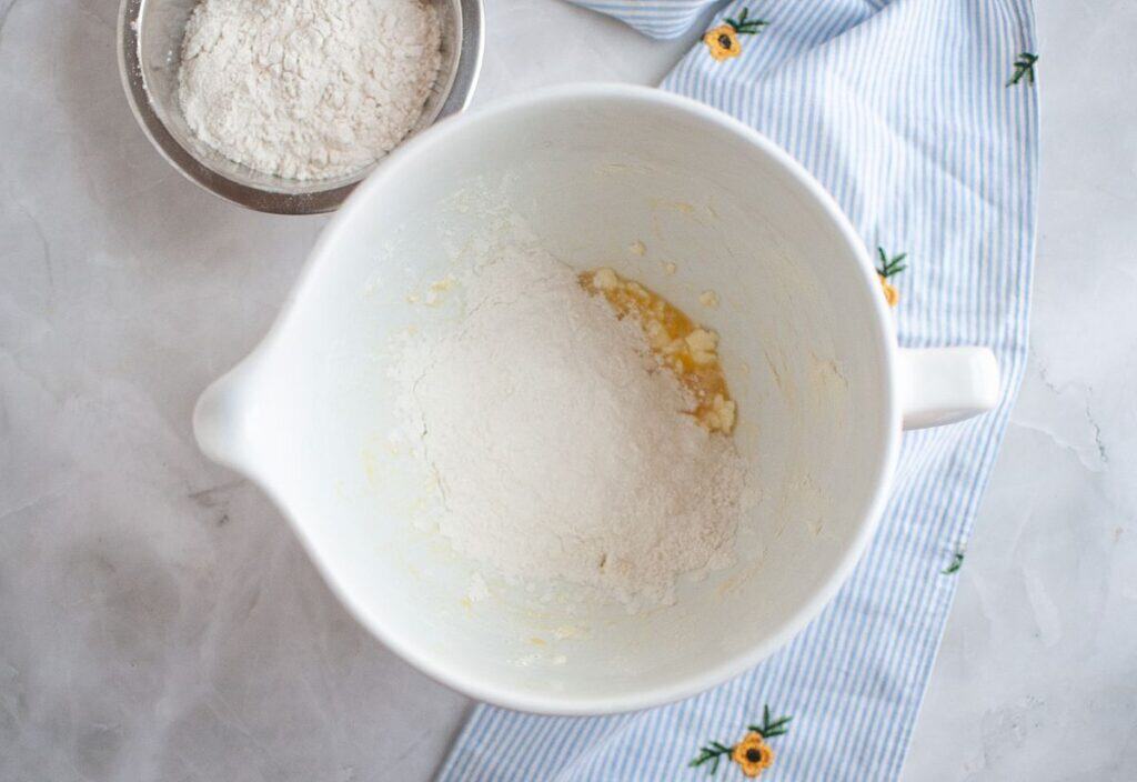 A bowl showing the addition of flour into the butter mixture, ready for mixing.