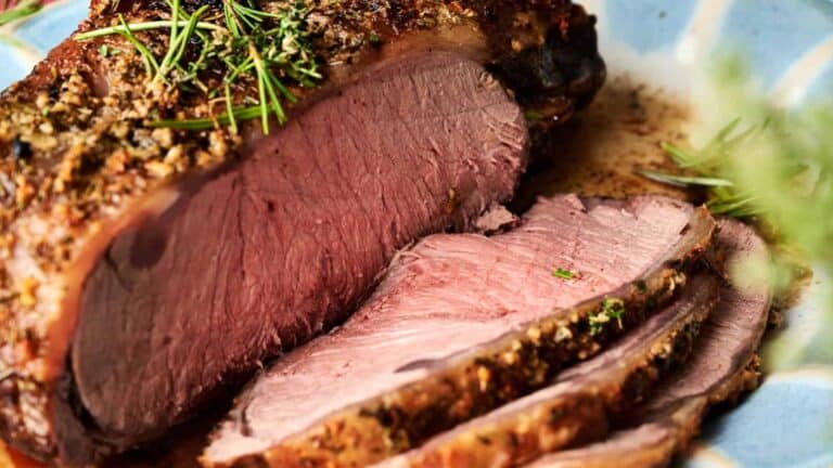 A beautifully roasted prime rib with a rich, golden crust, garnished with fresh herbs and ready to serve.