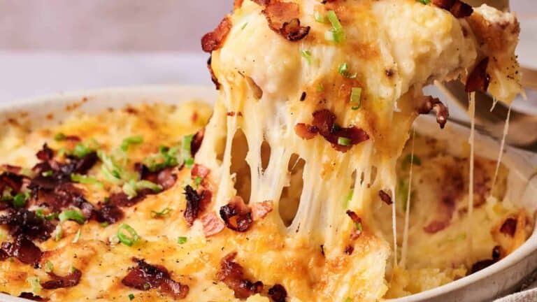 A hearty dish of creamy mashed potatoes topped with melted cheese and crispy bacon bits, baked to perfection.