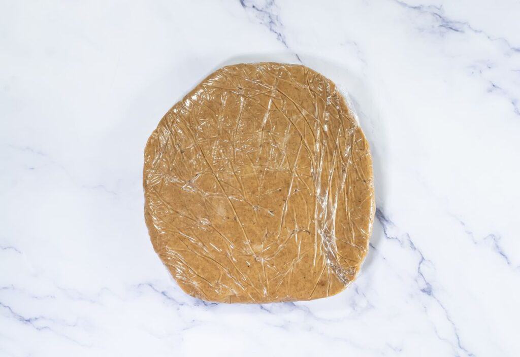 The chilled cookie dough wrapped in plastic, ready for rolling out and cutting into shapes.