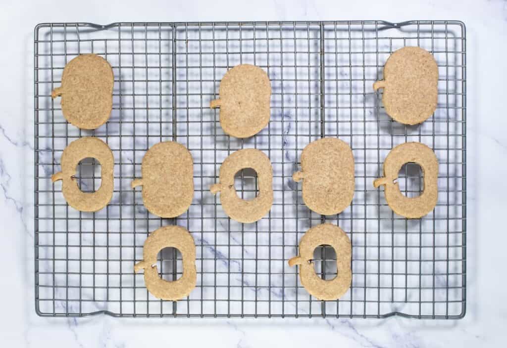 Pumpkin cookies with pumpkin butter filling placed on a wire rack, ready for assembly.