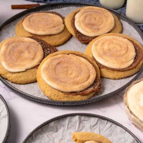 Crumbl copycat cinnamon swirl cookies topped with cream cheese frosting on a serving tray.