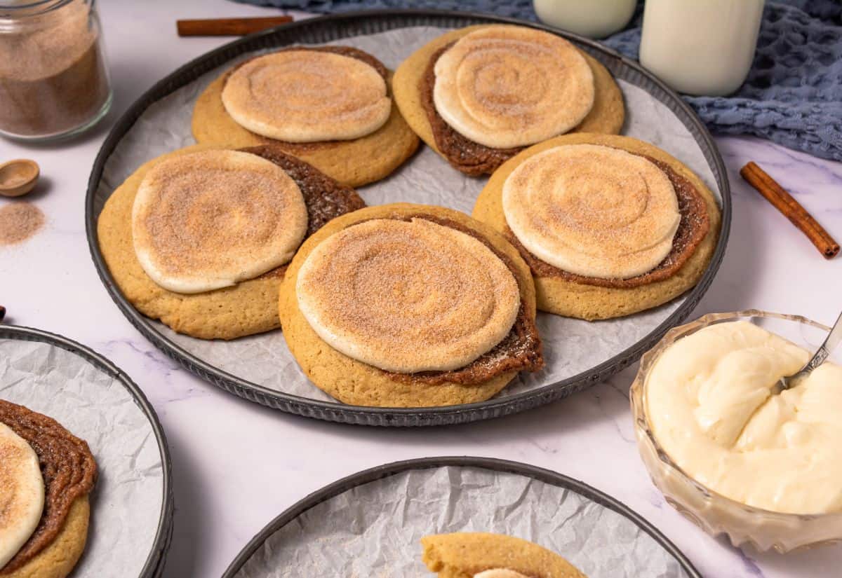 Crumbl copycat cinnamon swirl cookies topped with cream cheese frosting on a serving tray.