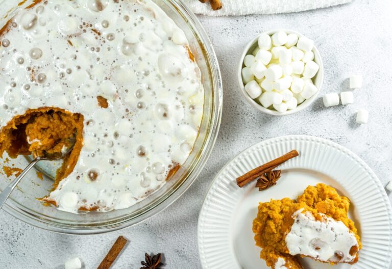 Sweet potato casserole topped with melted marshmallows in a glass baking dish.