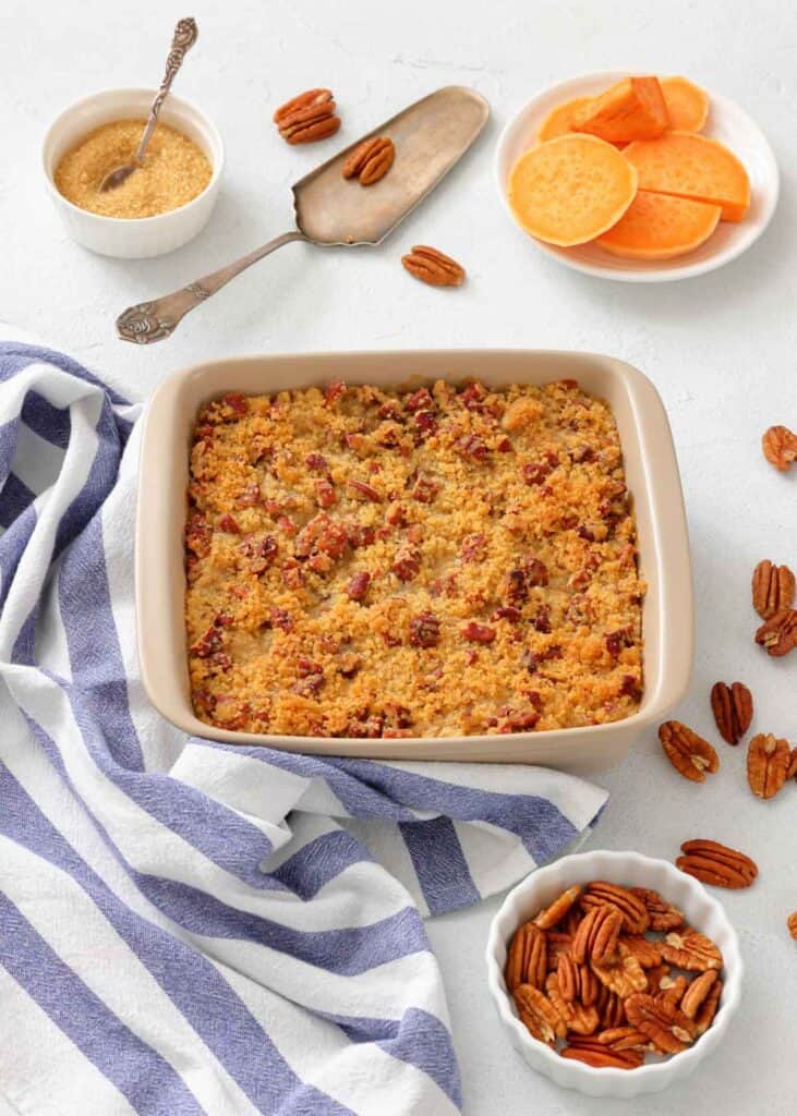 The prepared sweet potato casserole with a pecan streusel topping in a baking dish, ready for the oven.