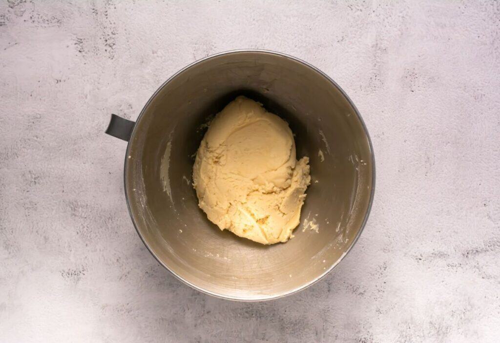 Cookie dough formed in a mixing bowl.
