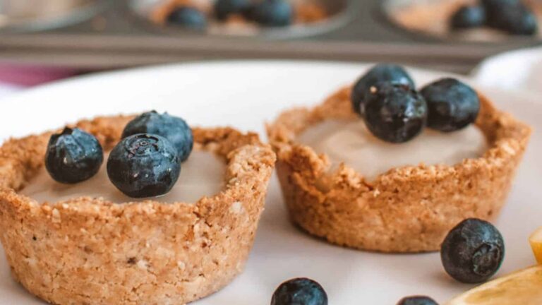 A plate with lemon and blueberry muffins on it.